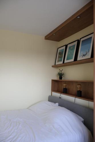- une chambre avec un lit blanc et trois fenêtres dans l'établissement Cosy Cocon - Appartement T2 - Sèvres, à Sèvres