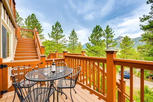 a wooden deck with a table and chairs on it at Estes Park Condo with Deck and Views about 3 Miles to RMNP in Estes Park