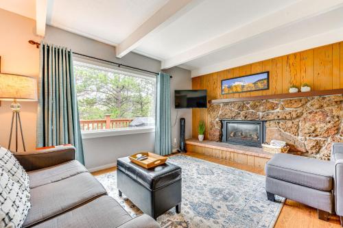 a living room with a stone fireplace at Estes Park Condo with Deck and Views about 3 Miles to RMNP in Estes Park