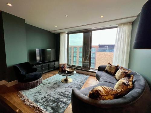 a living room with a couch and a large window at The Card Room at Ryedale House in York