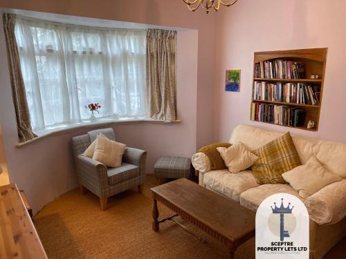 a living room with a couch and a chair at Beautiful Self-contained Cottage in Ickenham