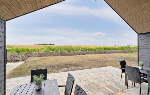 a patio with a table and chairs and a field at Nice Home In Otterup With Sauna in Otterup