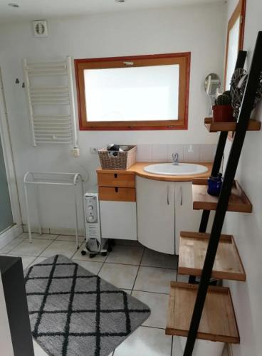 une petite salle de bain avec un lavabo et une fenêtre dans l'établissement Le gîte du bout, à 100m de la mer, à Asnelles