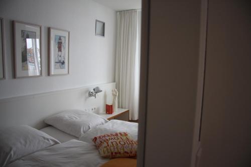 a bedroom with a bed with two pillows on it at Feriendomizil am Kurplatz in Norderney