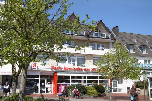 a building with people riding motorcycles in front of it at Feriendomizil am Kurplatz in Norderney