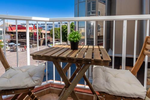 a wooden table and two chairs on a balcony at Calas Beach Corralejo in Corralejo