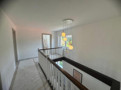 a hallway with a staircase with a mirror and a chandelier at Inn Nature in Pale