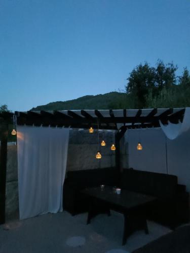 a patio with a couch and an umbrella and a table at Stone Chalets - LUNA in Jajce