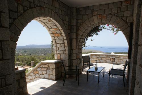 a patio with two arches in a stone wall at Thelea Mani in Kafióna