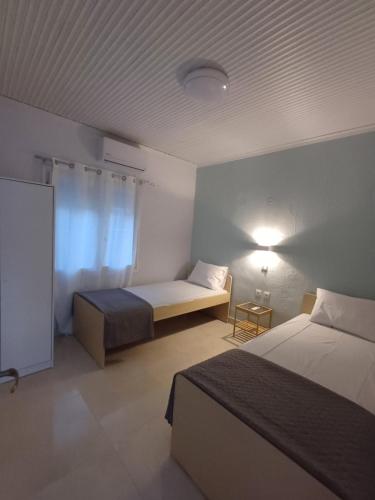 a hotel room with two beds and a window at Angie's House Sykia in Sikia