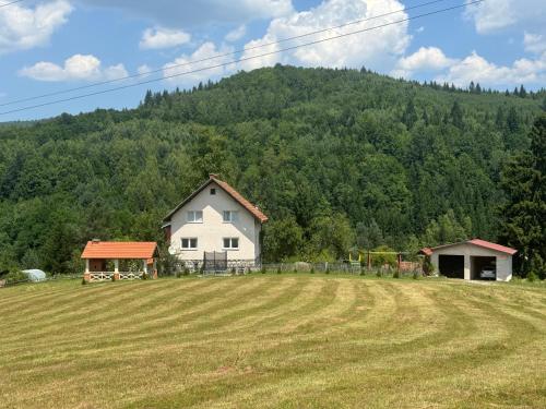 a house in a field with a hill in the background at Inn Nature in Pale