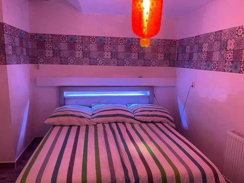 a bedroom with a striped bed with a light above it at Y Hoa-Ferienzimmer in Artern