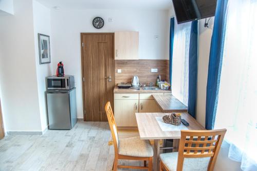 a kitchen with a table and chairs and a kitchen with a refrigerator at Panská in Chlum u Třeboně