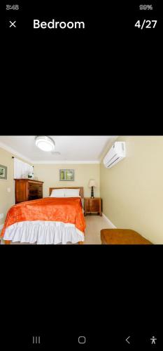 1 dormitorio con 1 cama con edredón de naranja en Pretige Studio, en Orlando