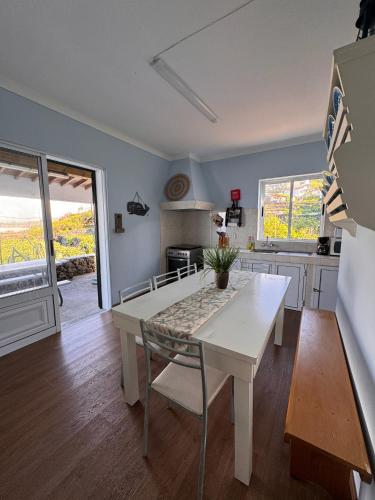 a kitchen with a white table and a dining room at Casa Beira Mar in Angra do Heroísmo