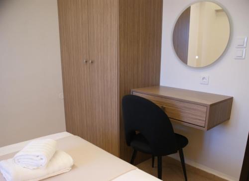 a room with a bed and a mirror and a chair at Thelea Mani in Kafióna