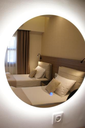 a hotel room with two beds and a mirror at Thelea Mani in Kafióna