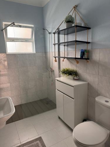 a bathroom with a toilet and a shower and a sink at Casa Beira Mar in Angra do Heroísmo