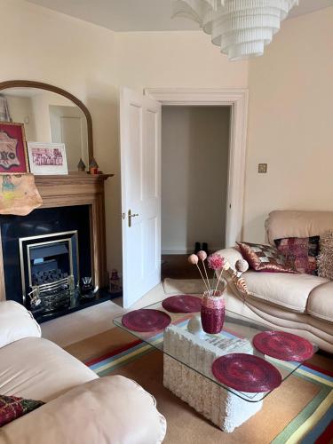 a living room with a couch and a fireplace at Private Room in Charming Detached House in Newington in Edinburgh