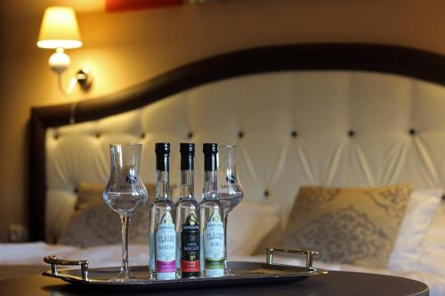 a tray with four bottles and wine glasses on a bed at Sáppusztai Vendégház in Damak