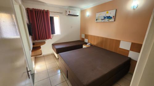 a small room with a bed and a window at diRoma Fiori - Apartamentos JN in Caldas Novas