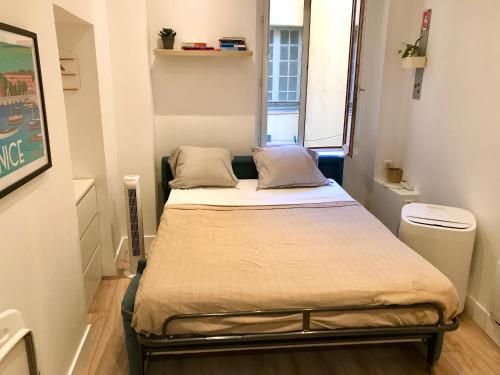une petite chambre avec un lit dans une pièce dans l'établissement 36 Rue Droite, à Nice