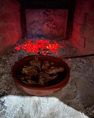 a bowl of food cooking in a brick oven at Kantina & Ferma Dukat in Vlorë
