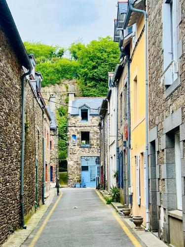 Une allée avec des bâtiments et une personne marchant dans une rue dans l'établissement Chez Marie, à Cancale