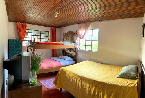 una camera con due letti e una tv di Hostal antaño a Duitama