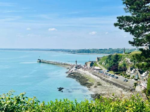 Una vista de un río con un muelle y coches. en Chez Marie, en Cancale