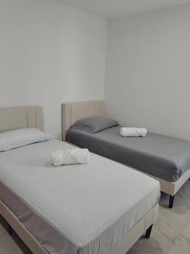 two beds sitting next to each other in a room at Cerca de Salones de Fiesta, con Alberca, AC e Internet in Xochitepec