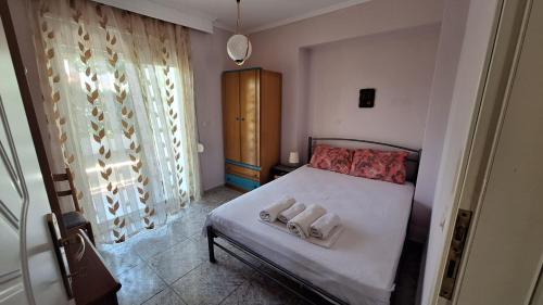 a bedroom with a bed with two towels on it at LY apartment in Kallithea Halkidikis