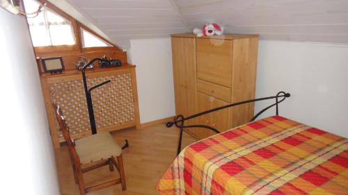 a bedroom with a bed and a dresser and a chair at Villa Sissi in Laives