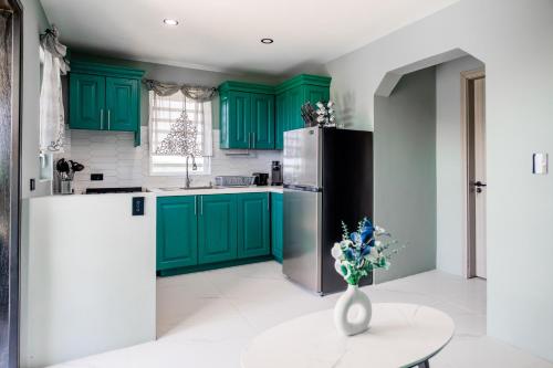 a kitchen with green cabinets and a vase with flowers at LeLuxe Cedar Valley Suite B in Woods