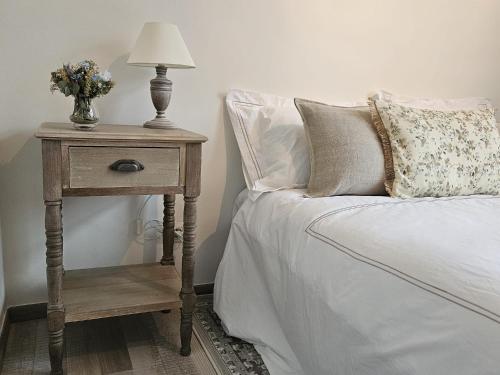 a bed with a table with a lamp on it at Die Scone B&B - Guestroom - Centre of Bruges in calm area in Bruges