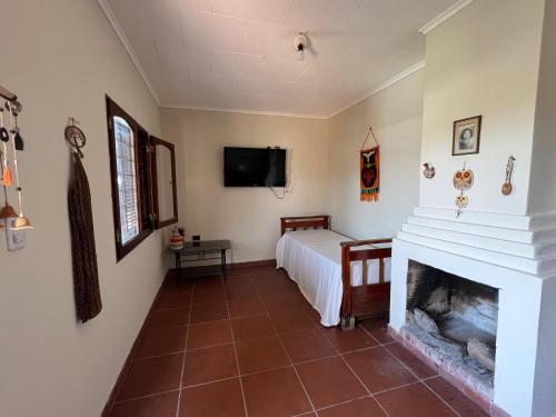 a living room with a fireplace and a tv at Casa Cadillal in El Cadillal