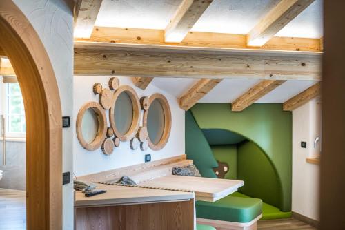 a room with green walls and wooden ceilings at Chalet Pineta relax location in Canazei