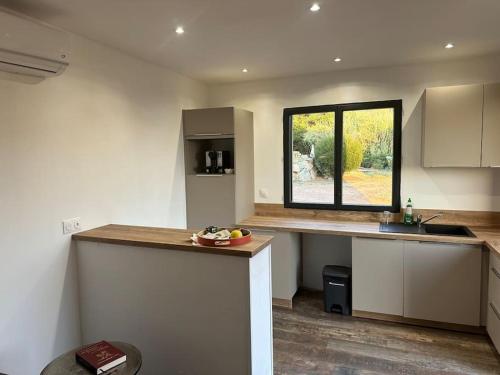 une cuisine avec un comptoir et une fenêtre dans l'établissement Appartement vue mer 5 min de la plage, à Cargèse