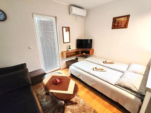 a bedroom with a bed and a table and a couch at Banjski cvet in Vrnjačka Banja
