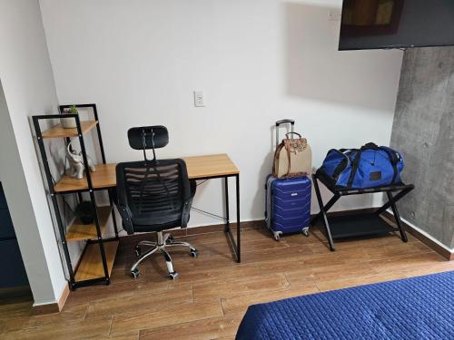 a room with a desk and two chairs and a backpack at Loft Barrio Vergel in Monterrey