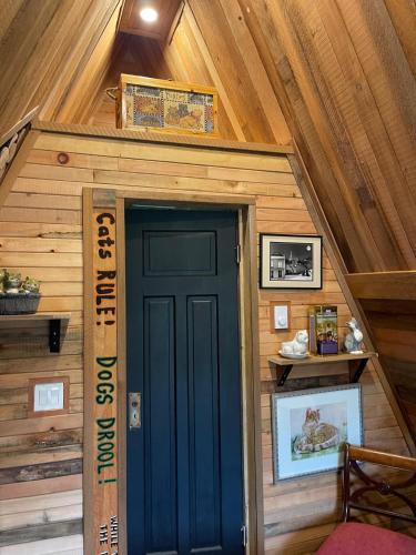 a tiny house with a blue door in the attic at Shannaghs Sweet Escape in Powell River