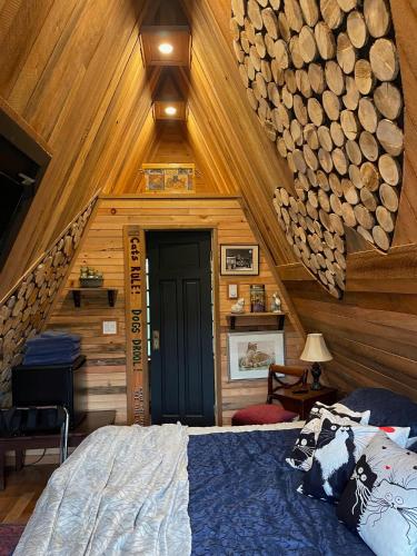 a bedroom with a bed in a room with wooden walls at Shannaghs Sweet Escape in Powell River