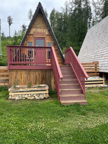 a cabin with a large deck and stairs on it at Shannaghs Sweet Escape in Powell River