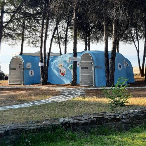 a blue trailer parked in front of some trees at Hippocampus House in Stratónion
