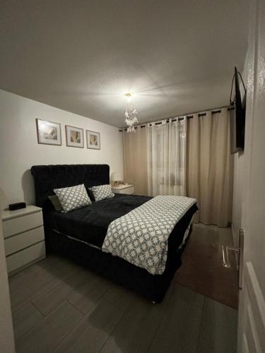 - une chambre avec un lit et une couette noire dans l'établissement Appartement t3 70 m2, à Vénissieux