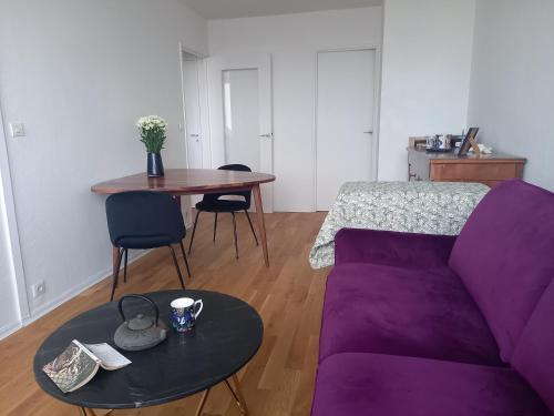 un salon avec un canapé violet et une table dans l'établissement Vue imprenable sur Paris, à Paris