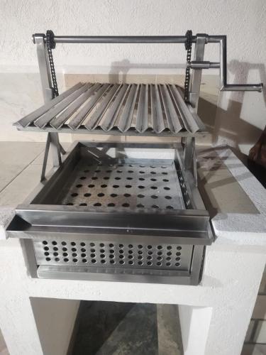 a metal shelf on top of a white table at Cerca de Salones de Fiesta, con Alberca, AC e Internet in Xochitepec