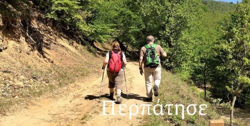 a man and a woman walking down a dirt trail at Hippocampus House in Stratónion