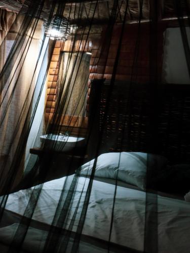 a bed and a chair in a room with a window at Valle Bucana in Santa Bárbara de Samaná