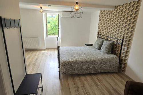 una camera da letto con un letto, uno specchio e una finestra di Aux deux Marronniers Cathares a Castelnau-de-Lévis